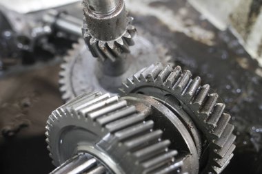 Mekanik vitesler yakından, karmaşık mühendislik ve hassasiyet gösteriyor. Metalik parıltı ve detaylı dişler sanayi ve mekanik işlevi çağrıştırıyor