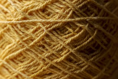 Sıcak sarı iplik yumağı yün iplik dokusunu gösteriyor. Örgü hobisi için el işi malzemelerinin özeti. Tığ işi projesi için karmaşık lif deseni