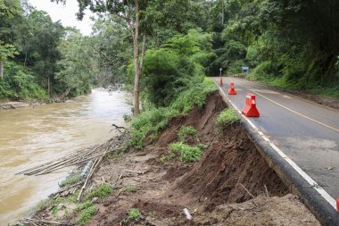 Heyelan ve ormanın sel baskınından kaynaklanan aşınma sonucu oluşan tehlikeli yol. Sahne, doğanın yıkıcı gücünü ve doğal felaketin sonuçlarını gösteriyor.