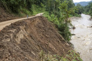 Yıkıcı toprak kayması kırsal yol boyunca toprak erozyonuna ve yıkıma neden olur. Akan nehirden gelen güçlü sel suları bu doğal afetin tehlikesini gösteriyor.