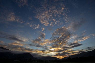 Güneşin doğuşunda ya da batışında sakin bulutlarla dolu güzel altın turuncu gökyüzü ilham verici bir manzara yaratıyor. Dramatik doğa sahnesi engin ufukta huzurlu ve umut dolu duygular uyandırır.