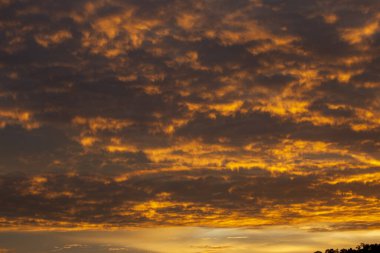 Huşu uyandıran günbatımı, parlak turuncu ve altın renklerle gökyüzünü boyar. Dramatik bulut oluşumları atmosferik ve ateşli bir görüntü yaratır. Ufku nefes kesici güzelliklerle doldurur.