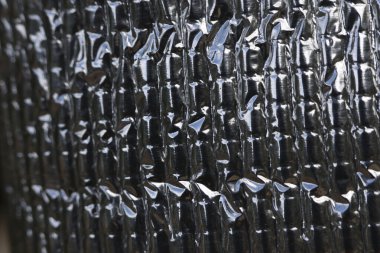 Close up of silver heat protection sheet with crinkled texture. This abstract background shows shiny, metallic surface, ideal for insulation and industrial use