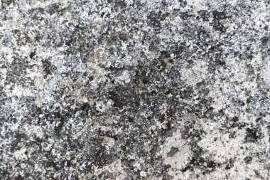 Rough, weathered gray stone texture background featuring granular surface. pattern showcases natural erosion and intricate details, ideal for design elements. This material conveys sense