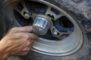 Araç tamiri ve bakımı sırasında odaklanmış mekanik eli kapat. Otomotiv tekerleğini tamir eden yetenekli biri, off-road arabasında lastik servisi yapan biri.