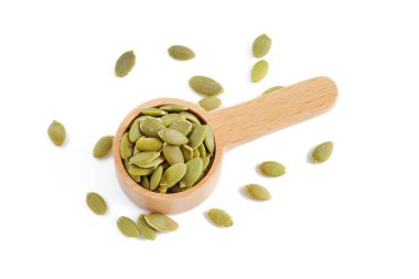 Tahta kaşıklardaki kabak tohumları beyaz arkaplanı kapatır.