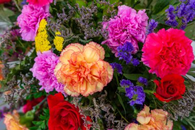 Mor ve kırmızı çiçekli bir buket çiçek.