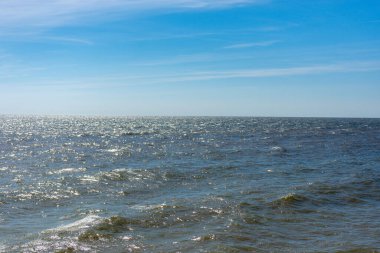 Dalgalar ve mavi gökyüzü ile deniz kıyısı