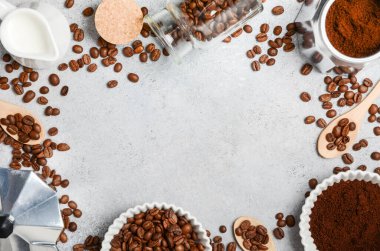 Kahve çekirdekleri ve öğütülmüş kahve, dokulu bir yüzeyde demleme aletleriyle güzelce düzenlenir. Sıcak ve davetkar bir kahve deneyimi uyandırır.