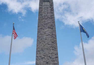 Bennington Vermont savaş anıtı ve mavi gökyüzüne karşı bayraklar.