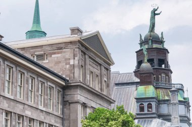 the facade and statues on top of Notre Dame de BonSecours Chapel and market in montreal Canada on an overcast day. clipart