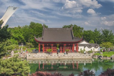 Montreal, Kanada. 6 Temmuz 2019 'da Kanada' daki Montreal Botanik Bahçesi 'ndeki küçük bir göletten yansıyan bir Çin binası..