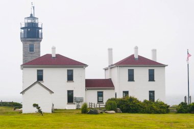 The historic landmark Beavertail lighthouse in Jamestown Rhode Island on a foggy day. clipart