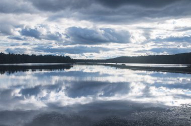 Ashley Reservoir sonbaharda Holyoke Massachusetts 'te mavi gökyüzünü yansıtıyor.