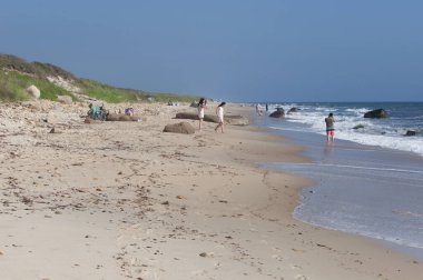 Baharın erken saatlerinde, Aquinnah Massachusetts 'te güneşli bir günde Moshup sahilindeki insanlar. 