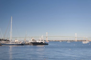 Güneşli bir günde Claiborne Pell Newport köprüsünün önündeki limana demirlemiş tekneler.