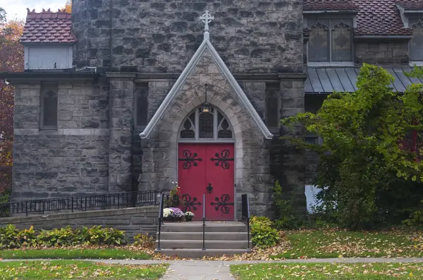 Sonbaharda Corning New York 'taki tarihi İsa Piskoposluk Kilisesi' ne kırmızı ahşap bir kapı ve giriş..