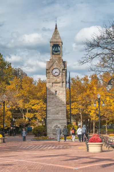 Corning, New York 'ta. 22 Ekim 2022. İnsanlar sonbaharda Corning New York 'un Gaffer Bölgesi' ndeki Centerway Meydanı 'nda saat kulesinin etrafında yürüyorlar..