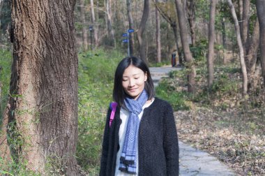 Çinli bir kadın Çin 'in Nanjing bölgesindeki Zhongshan ormanında taş bir yola bakıyor..