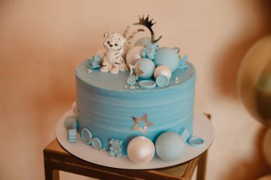 Blue cake on a baby holiday. Birthday boy with balls