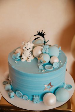Blue cake on a baby holiday. Birthday boy with balls