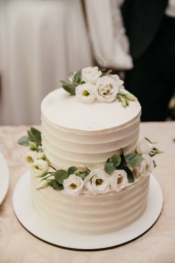 İki katlı, çiçekli beyaz pasta.