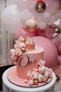Topların arka planında bebek pembe doğum günü pastası
