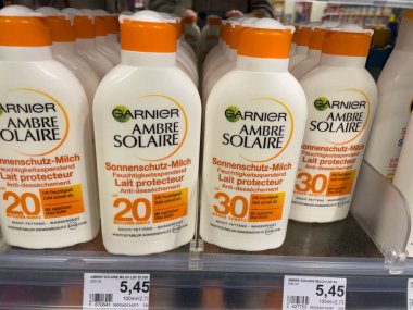 Berlin, Almanya - 27 Aralık 2021: Garnier Ambre Solaire güneş kremi şişeleri. Garnier, Fransız kozmetik şirketi L 'Oreal' in bir kitle pazarı kozmetik markası. Saç bakımı ve cilt bakım ürünleri üretiyor.