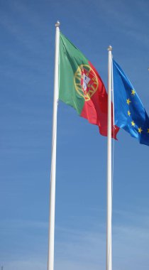 Lizbon, Portekiz - 26 Mayıs 2024: Portekiz ve Avrupa Birliği bayrakları mavi gökyüzüne el sallıyor