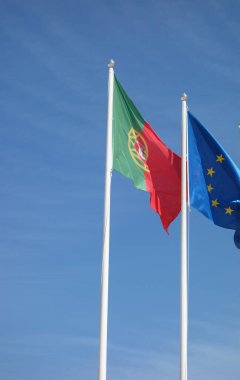 Lizbon, Portekiz - 26 Mayıs 2024: Portekiz ve Avrupa Birliği bayrakları mavi gökyüzüne el sallıyor