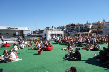 Cascais, Portugal - July 2, 2024: People watching the Netherlands vs. Romania Uefa European Championship game in the Euro Park fan zone, Cascais, Portugal clipart