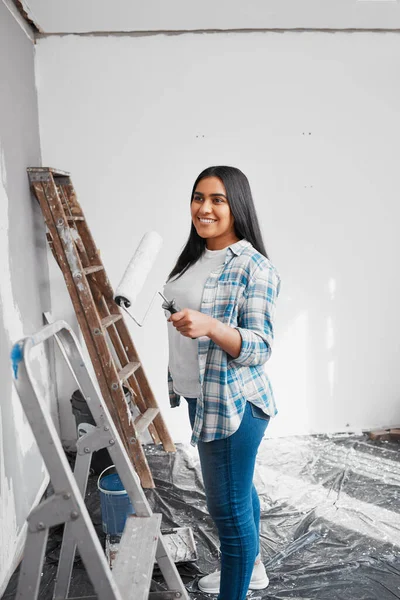 A young Indian woman prepares to paint a wall during home DIY project. High quality photo