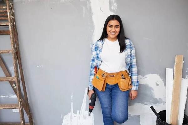 An attractive young Indian woman leans against wall doing home DIY renovation. High quality photo