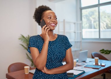 Genç siyahi iş kadını toplantı odasında cep telefonuyla gülümsüyor. Yüksek kalite fotoğraf