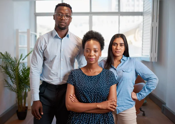Group of serious business people pose arms folded in office, diverse trio. High quality photo