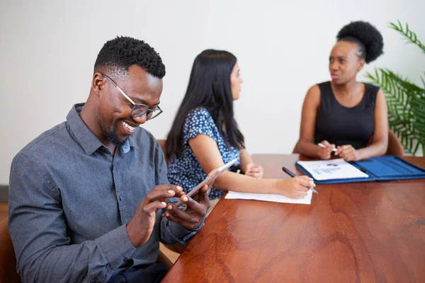 Hombre Negocios Negro Sonríe Mientras Usa Tableta Digital Reunión Mesa — Foto de Stock