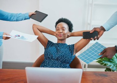 Young Black woman relaxes in her office while coworkers make demands. High quality photo clipart