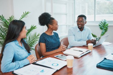 Üç farklı meslektaş, ofisteki yönetim kurulu masasında mali durumu tartışıyor. Yüksek kalite fotoğraf