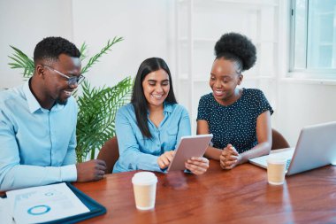 Genç iş kadını, meslektaşlarına ofis odasındaki tableti kullanarak açıklıyor. Yüksek kalite fotoğraf