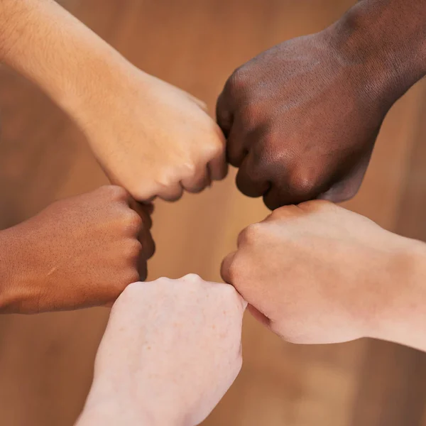 Circle of diverse hands, fists in circle, different skin colours unity teamwork. High quality photo