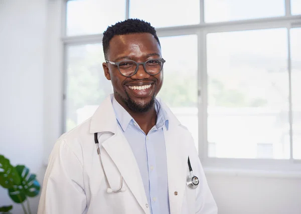 Portrait of smiling Black doctor in front of window in clinic. High quality photo