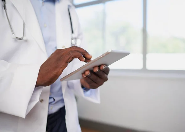 Close up of Black doctor entering patient information into digital tablet. High quality photo