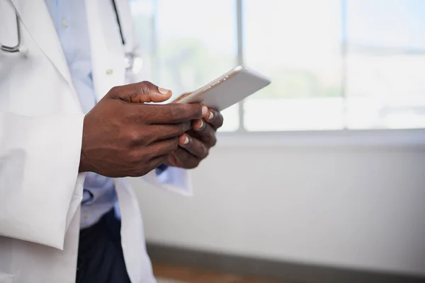 Close up of Black doctor entering patient information into digital tablet. High quality photo