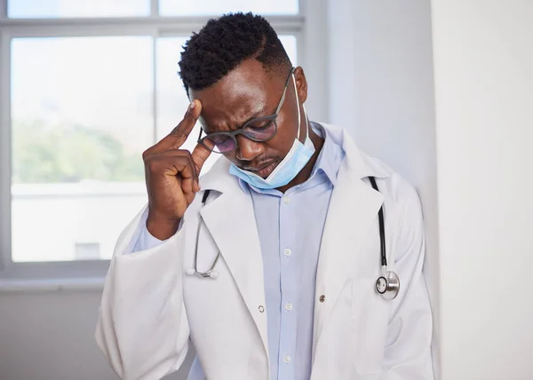 Black doctor looks upset after surgery wearing medical mask, stressed. High quality photo