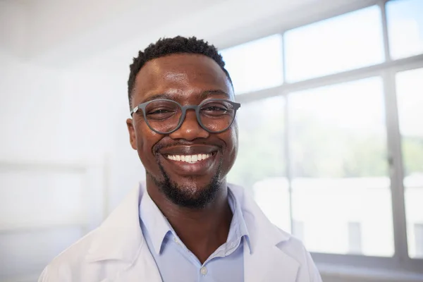 Close up portrait of smiling Black doctor with window. High quality photo