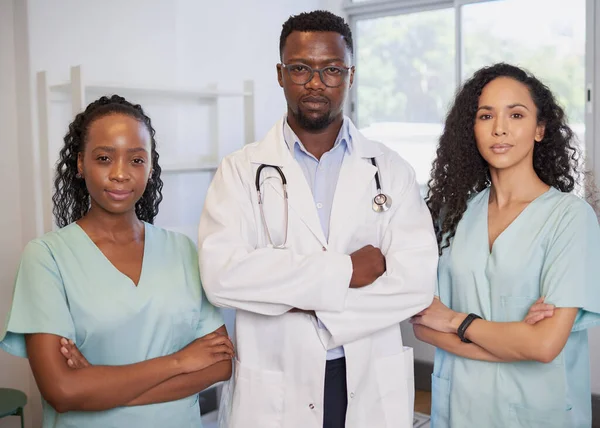 Three serious medical healthcare professionals stand in a row arms folded. High quality photo