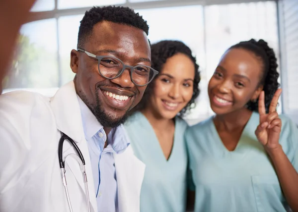Fun selfie of three healthcare professionals stand in a row informal candid pose. High quality photo