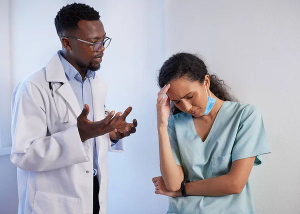 Senior doctor talks to upset junior doctor in scrubs, support mentorship. High quality photo