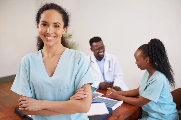 Portrait of smiling nurse standing in medical conference room with colleagues. High quality photo