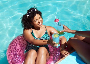 İki arkadaş havuzda keyifli keyifli kokteyller içiyor, şişme yüzüyorlar. Yüksek kalite fotoğraf